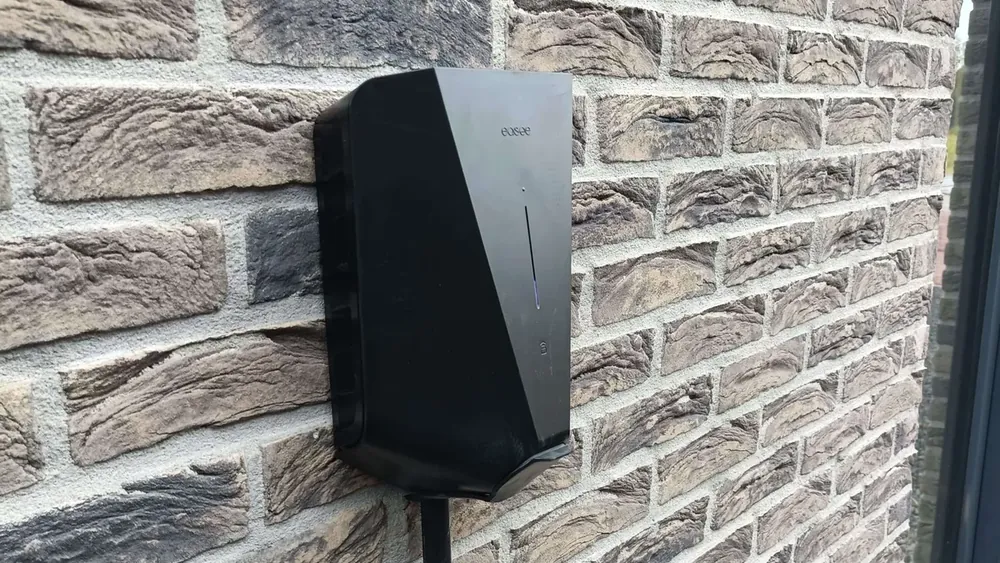 Door DeElektraMan geïnstalleerde Easee laadpaal op een montagepaal tegen een bakstenen gevel in Almere