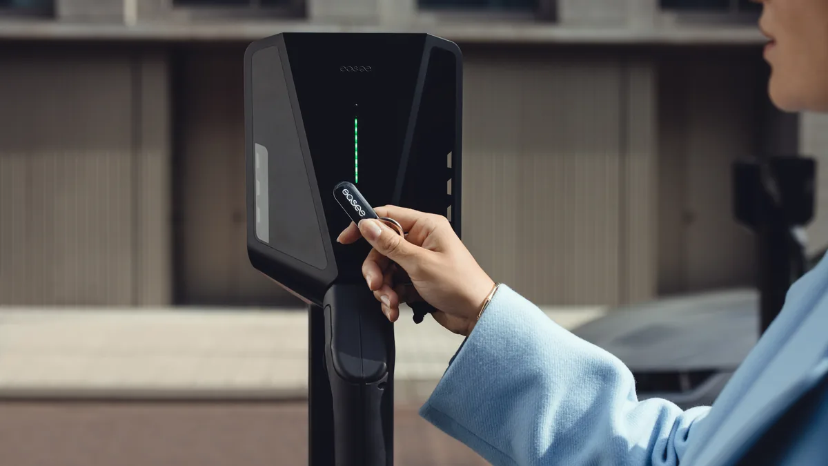 Hand houdt een Easee RFID-sleutel tegen de laadpaal om de laadsessie te starten