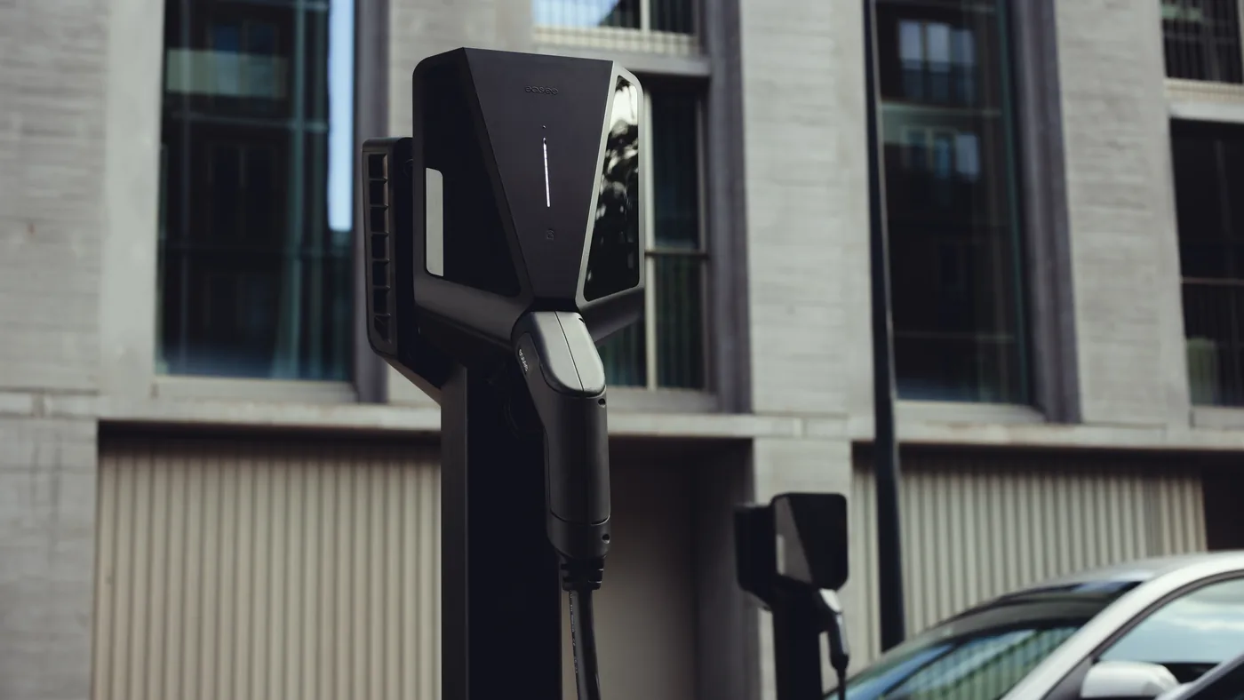 Easee laadpaal op een montagepaal naast een geparkeerde elektrische auto